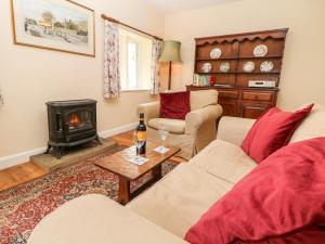 StocksbridgeUnderbank Hall Cottage的带沙发和炉灶的客厅