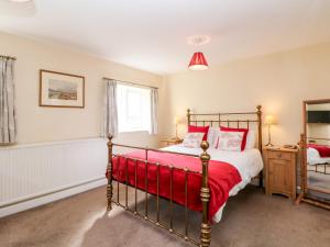 StocksbridgeUnderbank Hall Cottage的一间卧室配有一张带红色毯子的床