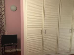 马德里Chalé Barajas Escala的卧室配有白色衣柜和电视。