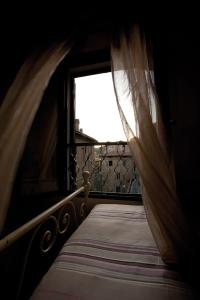 萨尔泰阿诺Casa Sant Angelo的一间卧室配有床和带窗帘的窗户