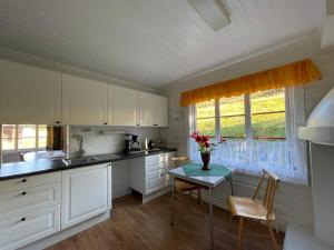 奥尔Olastugu的厨房配有白色橱柜和鲜花桌