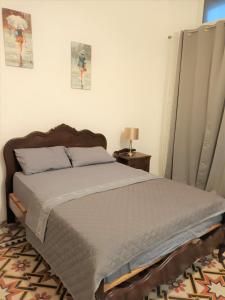 莫斯塔Villa Mosta的一间卧室配有一张床和一张带台灯的桌子