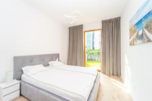 格但斯克Nadmorski Dwór - Green Apartment的白色的卧室设有一张大床和一个窗户