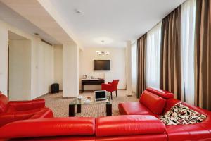 罗兹Hotel Borowiecki的客厅配有红色的沙发和桌子