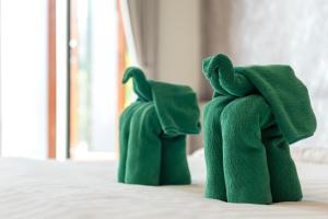 象岛象岛阶段酒店的两只绿色填充物的动物坐在床上