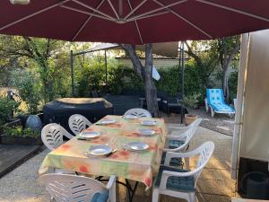 勒米伊Mobile-home aux Cigales,Le Muy Colorado 4-6 Personnes的庭院内桌椅和遮阳伞