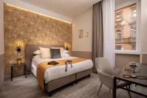 罗马Sophie Terrace Hotel的酒店客房设有一张大床和一张书桌。