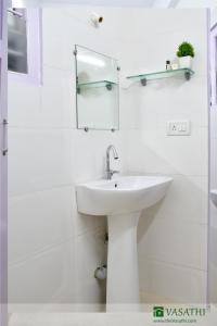 马迪凯里Vasathi的白色的浴室设有水槽和镜子