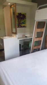 伯诺尼SUN1 BENONI的客房设有一张床、一张书桌和一面镜子