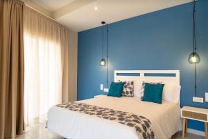 圣安东尼奥·德·卡隆Hotel Aubí的一间拥有蓝色墙壁和一张大床的卧室