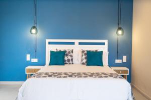 圣安东尼奥·德·卡隆Hotel Aubí的蓝色的卧室设有白色的床铺和蓝色的墙壁