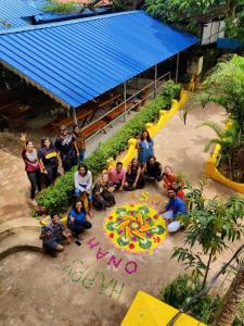 瓦尔卡拉The Lost Hostel, Varkala - Helipad的一群人在花园里拍照