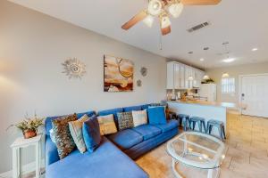 彭萨科拉海滩Baywatch G1的一间带蓝色沙发的客厅和一间厨房
