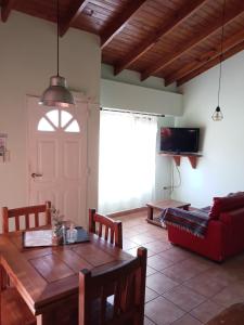 本塔纳山村Casas Serranas Margaritas的客厅配有木桌和红色沙发