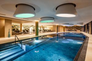 波尔莱扎ARIA Retreat & SPA - The Leading Hotels of the World, located within Parco San Marco Resort的酒店大堂的蓝色海水游泳池