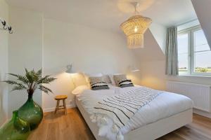 科尔特马尔克Villa Boho的卧室配有一张带花瓶的大型白色床