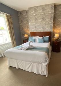 汤顿The Great Western Hotel的卧室配有带蓝色枕头的大型白色床