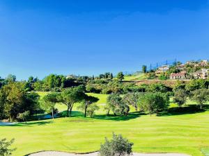 马拉加Buenavista Golf La Torre的享有高尔夫球场的树木和房屋美景