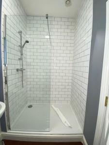 汤顿The Great Western Hotel的带淋浴的浴室和白色瓷砖墙