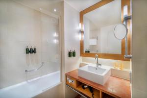 柏林柏林美利亚酒店的一间带水槽、淋浴和镜子的浴室