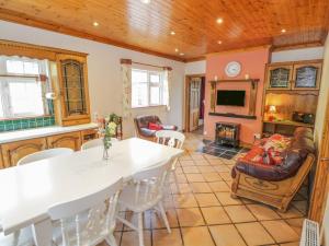 CollooneyClodagh's Cottage的厨房以及带桌椅的起居室。