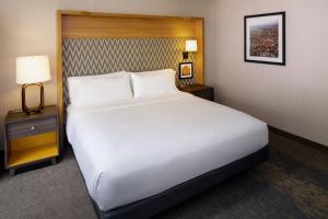 夏洛茨维尔Holiday Inn Express & Suites Charlottesville, an IHG Hotel的一张大白色的床,位于酒店客房内