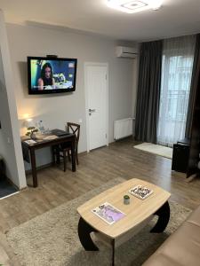 利沃夫塞萨尔酒店的客厅配有桌子和墙上的电视