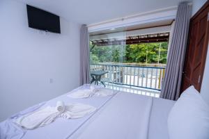 莫罗圣保罗Hotel do Pescador的一间卧室设有一张床,阳台配有电视。