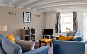 马汉莱斯Bwthyn Gweilch的客厅配有2张蓝色沙发和电视