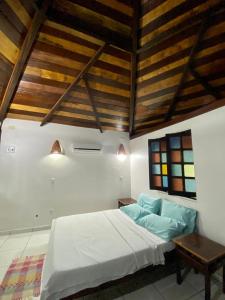 贝伦ReservAmazon Forest Hotel的卧室设有白色的床和木制天花板。