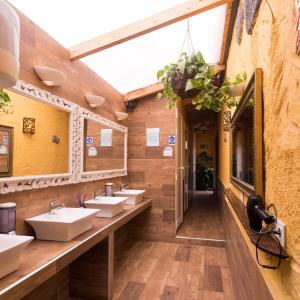 La MaretaLos Amigos NEST hostel的浴室设有4个水槽和一排镜子