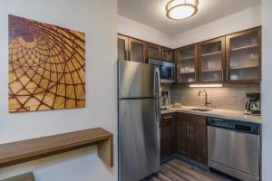 安克雷奇Staybridge Suites Anchorage, an IHG Hotel的厨房配有不锈钢冰箱和木制橱柜