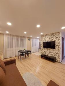 古尔贝内M14 Apartment的客厅配有桌子和墙上的电视