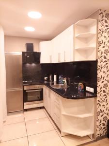 古尔贝内M14 Apartment的厨房配有白色橱柜和黑色台面