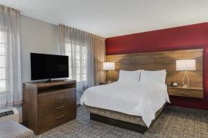 安克雷奇Staybridge Suites Anchorage, an IHG Hotel的配有一张床和一台平面电视的酒店客房