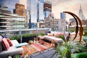 纽约Selina Chelsea的阳台配有沙发和植物,享有城市天际线