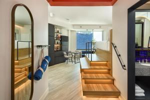 丹佛Catbird Hotel的客厅和厨房设有通往用餐室的楼梯