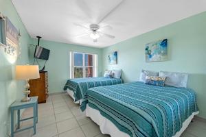 南帕诸岛Charming 1 Bedroom, 3 Minute Walk To The Beach Condo的蓝色墙壁客房的两张床