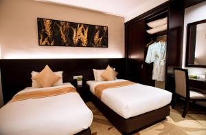 新山阿曼萨丽公寓度假酒店的酒店客房,配有两张床和椅子