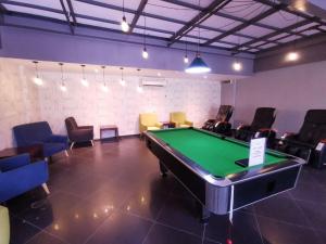新山阿曼萨丽公寓度假酒店的配有台球桌和一些椅子的房间