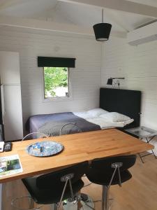图默利拉Skogsbäckens stugby AB的一间卧室配有一张床和一张木桌及椅子