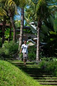坎古卡拉帕瑜伽精品度假村 的棕榈树之间的小径上走的人