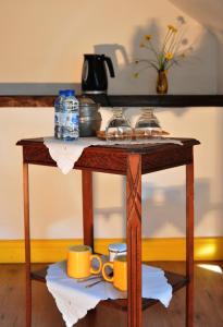 BioncourtLe Clos des Pommes的一张木桌,上面有杯子和盘子