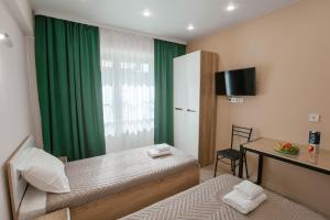 伊尔库茨克Апартаменты Изумруд возле Аэропорта на 2 гостя的客房设有两张床、一张桌子和一个窗户。