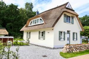 格洛韦Ferienhaus Zeitlos的白色的茅草屋顶房屋
