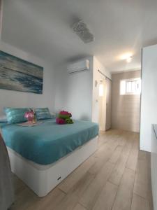 卡门港BLU的一间卧室配有一张带蓝色床单的大床
