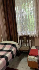 克列缅丘格Hotel Uyut的客房设有两张床、一个窗户和椅子。
