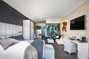 圣塔克里斯蒂纳阿鲁Suites Natura Mas Tapiolas的一间卧室设有一张床和一间客厅。