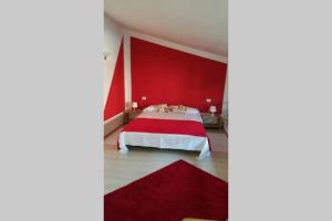 瓦雷泽Honeycomb - casa vacanze的红色的卧室,配有一张红色墙壁的床