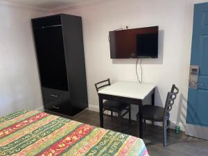 奥克兰奥克斯汽车旅馆的一间卧室配有一张床、一张桌子和一台电视。